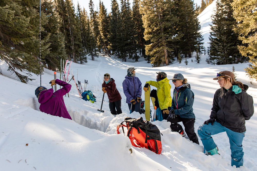 Women backcountry safety students gather around a snow pit Photo Julia Ordog