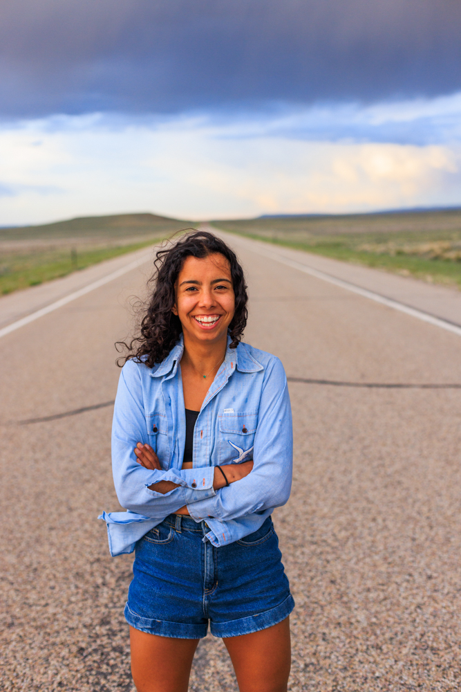 Standing on a lonely Wyoming highway with a summer thunderstorm building behind me. Photo by Sofia Jaramillo.